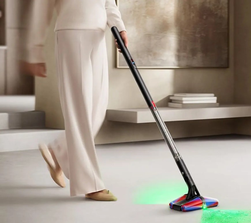 A side-profile view of the Dyson PencilVac highlighting the 38mm handle diameter and the linear airflow wand on a minimalist concrete background.