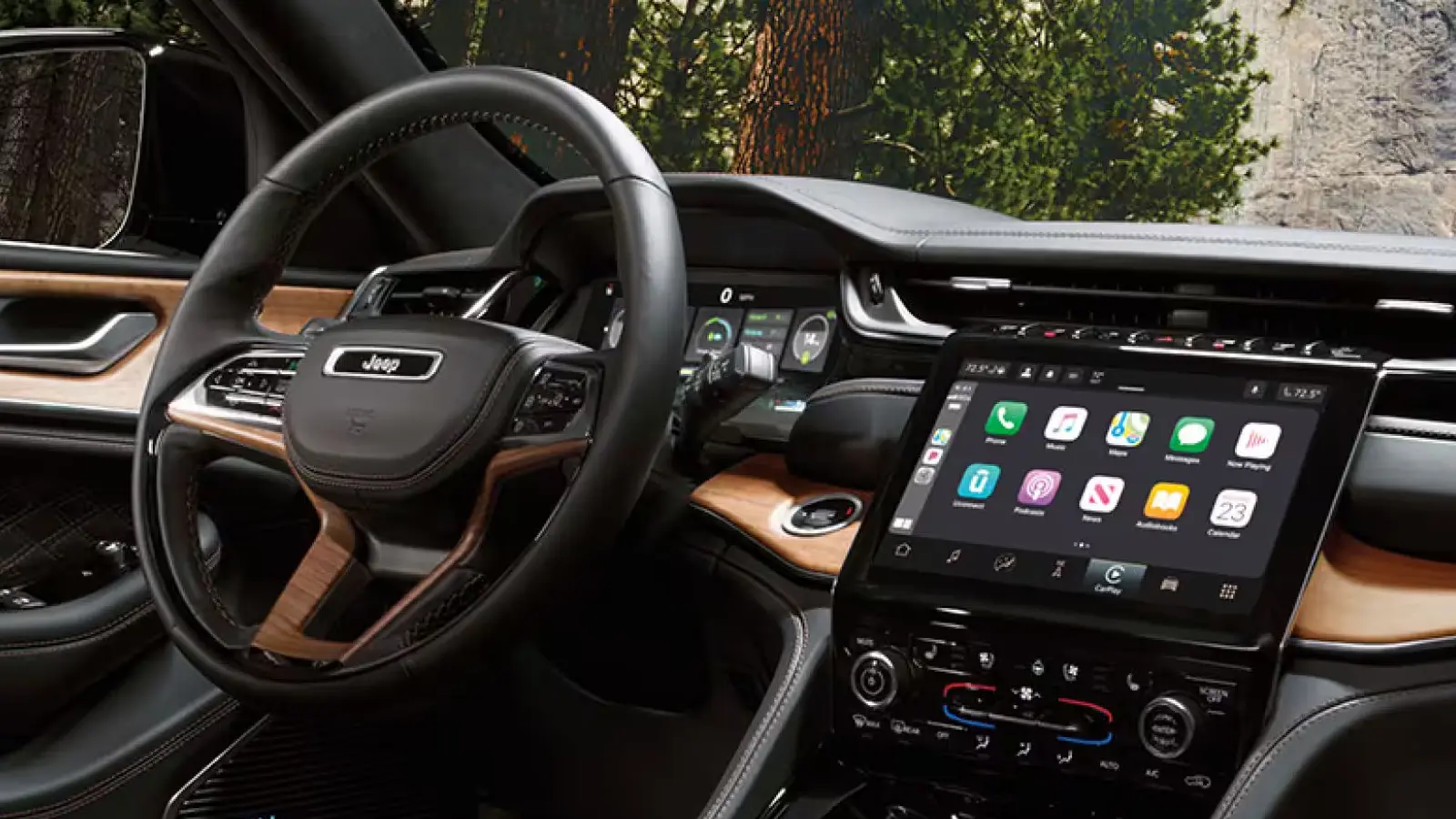 Interior dashboard of the 2025 Jeep Grand Cherokee Summit featuring the 10.1-inch Uconnect 5 touchscreen, digital cluster, and McIntosh MX950 audio blue meter interface.