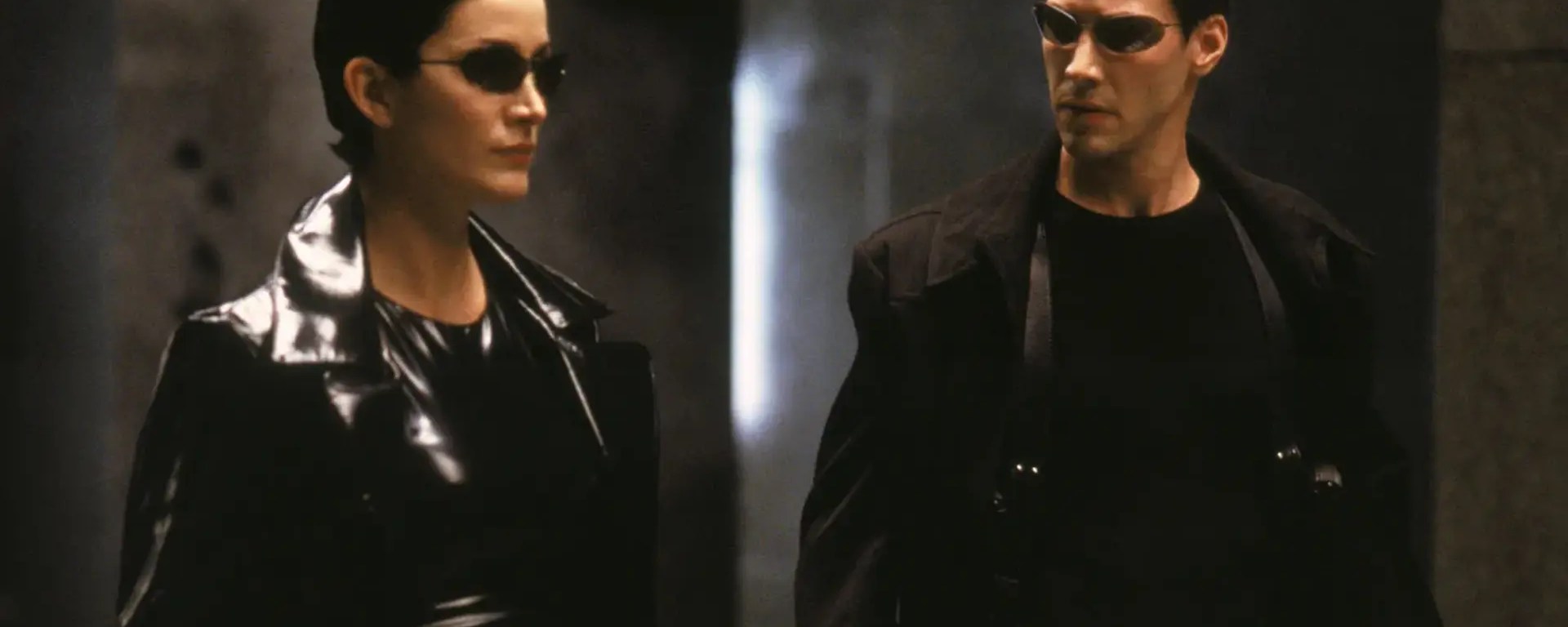 Close-up of Neo, played by Keanu Reeves, wearing black sunglasses in a scene from The Matrix (1999).