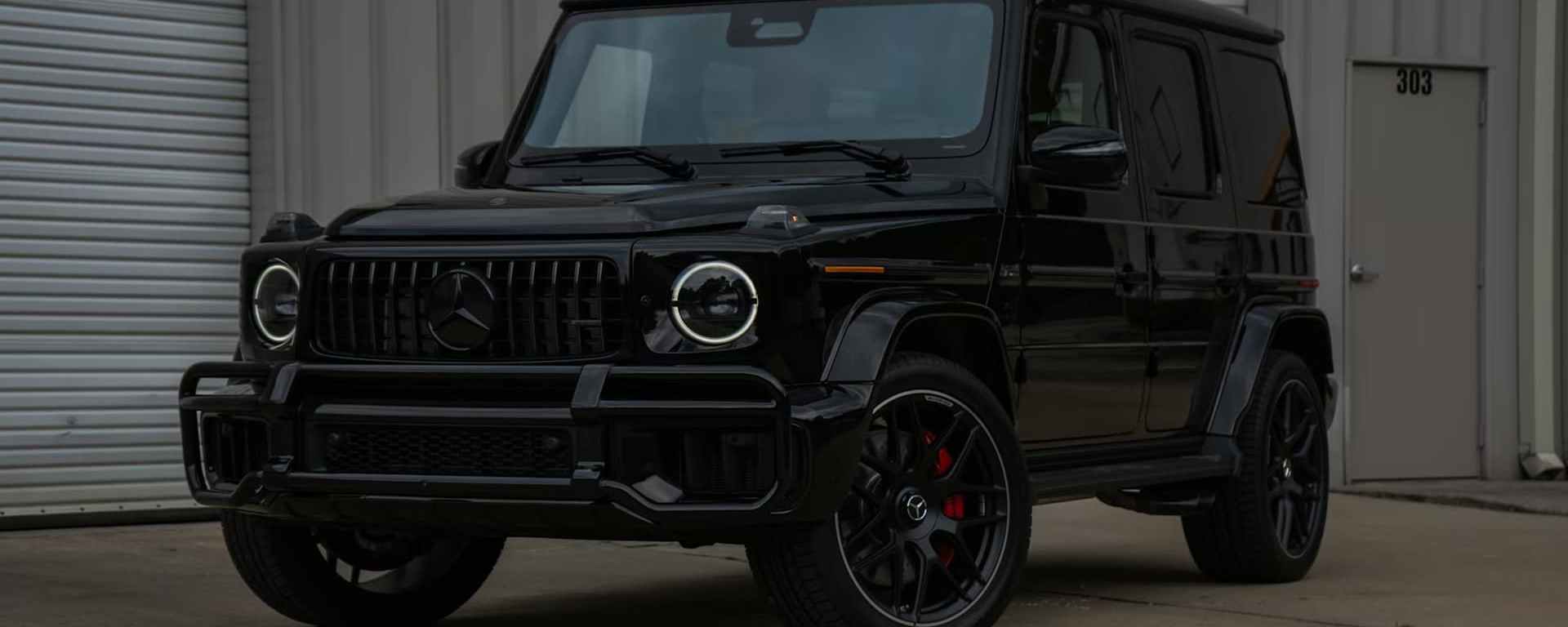 Black Mercedes-Benz G-Class SUV parked on a city street, showcasing its iconic boxy design.