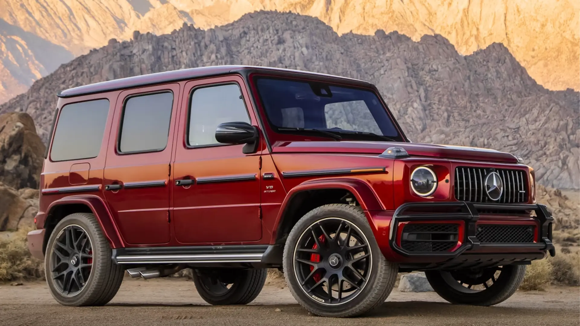 Red Mercedes-Benz G-Wagon parked on a city street, highlighting its boxy silhouette and luxury design.