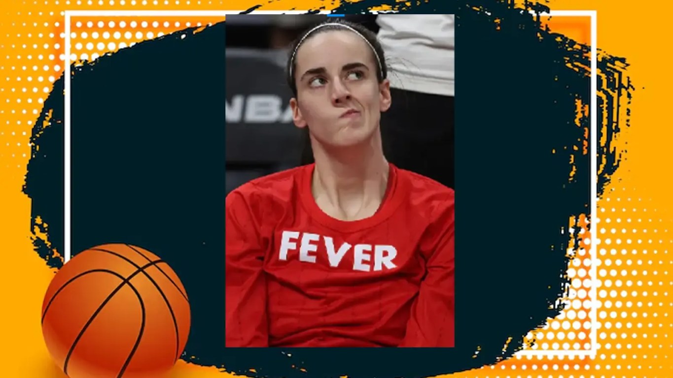 Indiana Fever guard Caitlin Clark (22) handling the ball near mid-court, looking to execute a high-range play. She is wearing the dark navy Indiana Fever uniform with vibrant red and yellow accents.