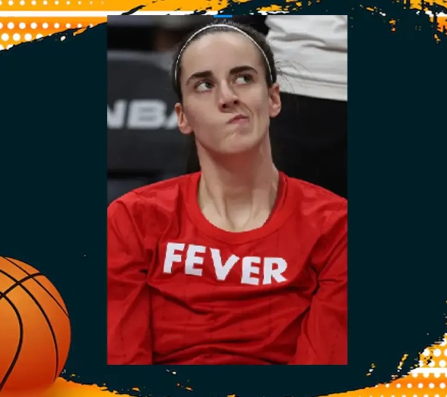 Indiana Fever guard Caitlin Clark (22) handling the ball near mid-court, looking to execute a high-range play. She is wearing the dark navy Indiana Fever uniform with vibrant red and yellow accents.