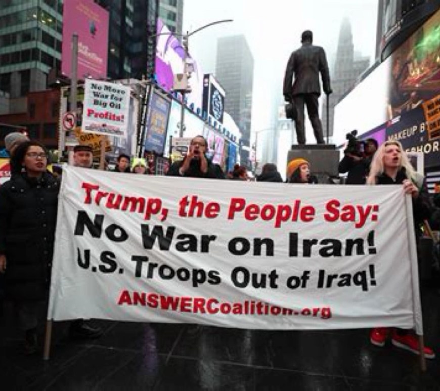 Raised hands behind a ‘STOP WAR’ banner, representing grassroots opposition to conflict and calls for de‑escalation.