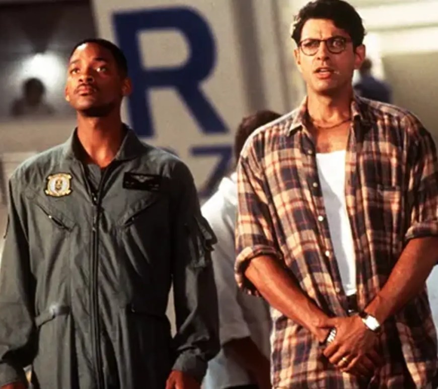 A movie still from Independence Day (1996) featuring the massive alien 'City Destroyer' spaceship hovering over the Empire State Building, symbolizing the film's $817 million global box office takeover.