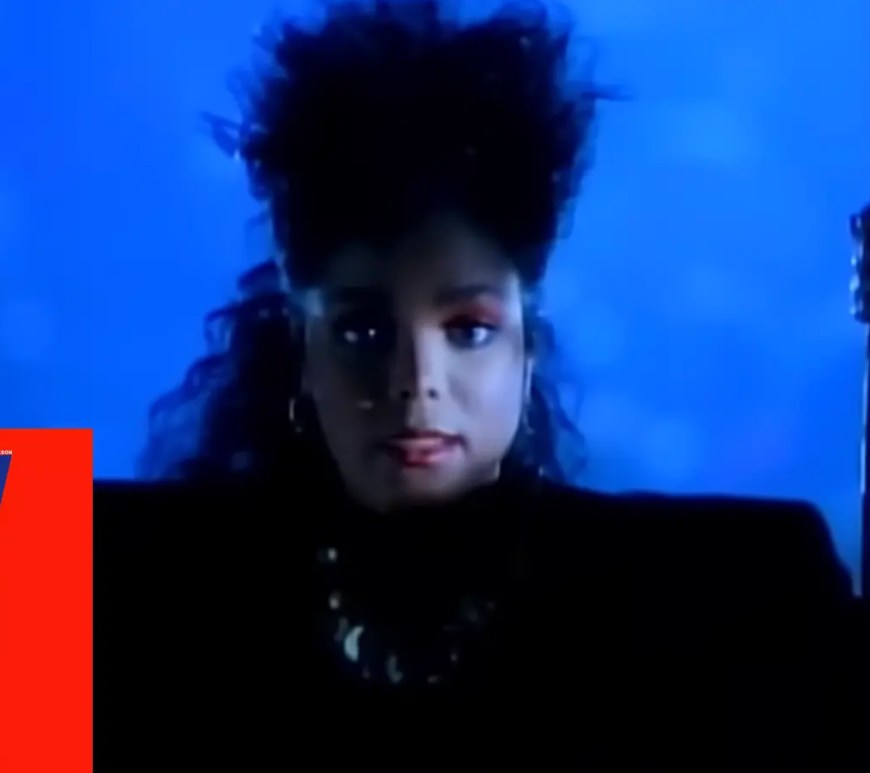 A music video still of Janet Jackson performing 'Control' at the Grand Olympic Auditorium in 1986, showcasing the sharp, angular choreography and industrial-inspired stage lighting that defined the era.