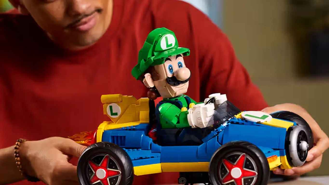 Detailed front profile look at the LEGO 72050 Luigi and Mach 8 Mario Kart. The 2,234-piece 1:8 scale model is pictured at a 30-degree drift angle on its custom display stand, highlighting the functional steering and mechanical flame exhaust.