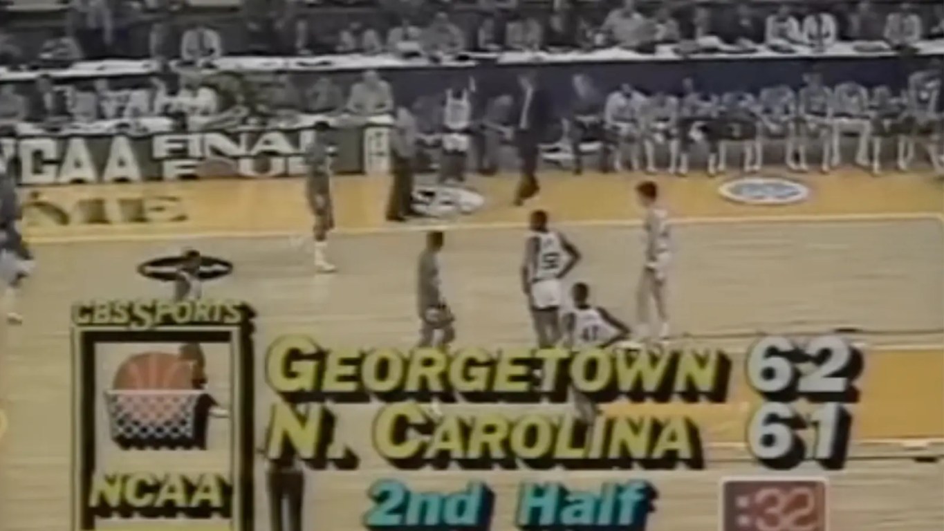 High-contrast archival photo of Georgetown vs North Carolina and the scoreboard.