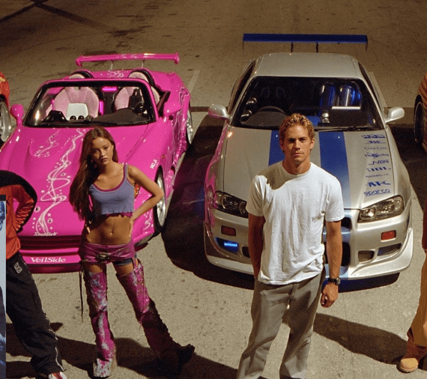 Cinematic wide shot from 2 Fast 2 Furious showing dozens of brightly colored tuner cars, including Toyota Supras and Mazda RX-7s, exiting a Miami warehouse simultaneously to evade police during the 'Scramble' sequence.