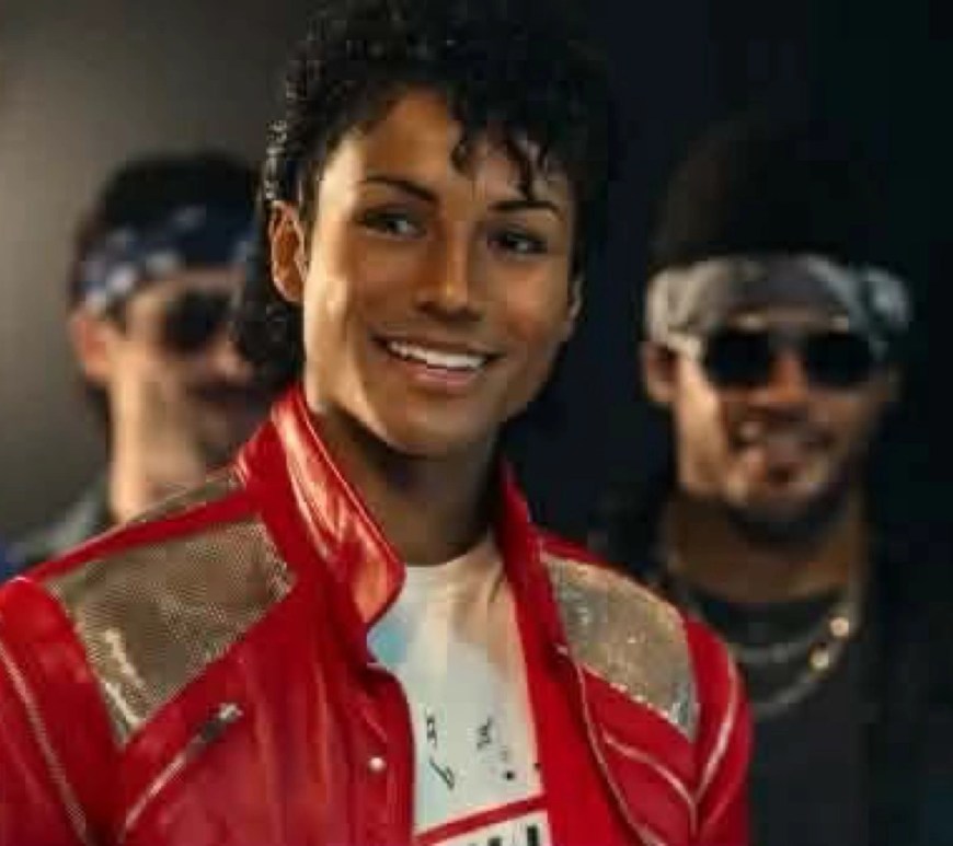 Is Michael On Track to Take the Musical Biopice... Jaafar Jackson, portraying Michael Jackson in the MICHAEL film, stands in a dimly lit alley wearing a bright red jacket with gold shoulder accents and a white shirt. He smiles slightly while looking off to the side, surrounded by background performers dressed in 1980s streetwear, evoking the iconic ‘Beat It’ music video atmosphere.
