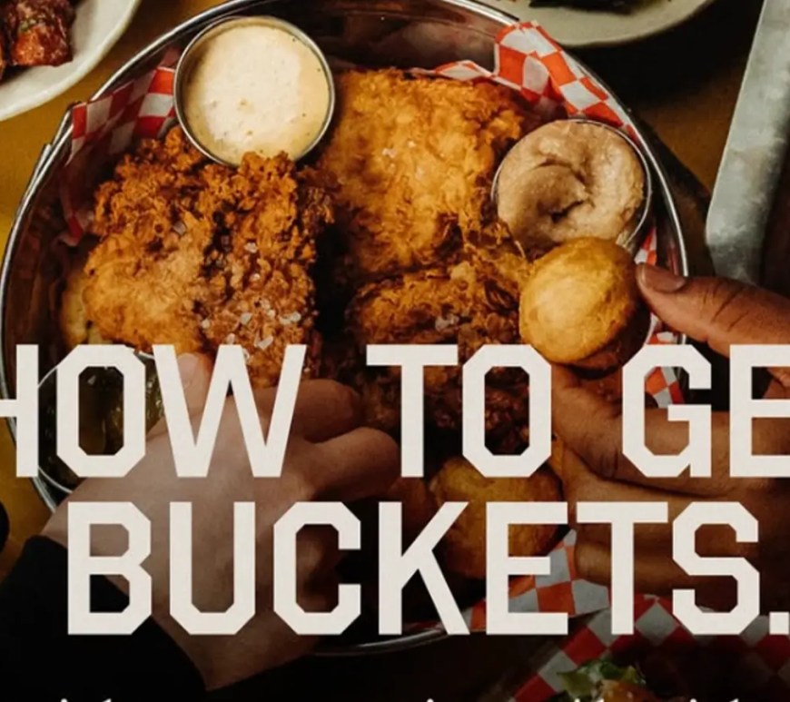 Menu of Buckets restaurant in Akron, Ohio, featuring modern communal seating and the LeBron James Family Foundation branding.