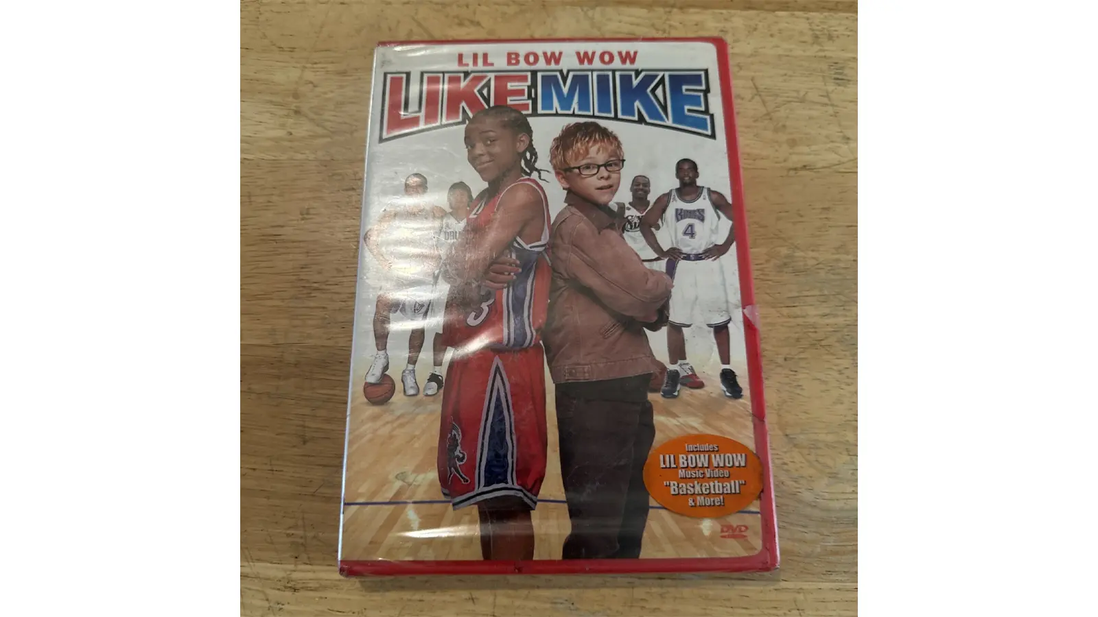The original Like Mike DVD cover featuring Lil' Bow Wow in a Knights jersey, holding a basketball with MJ’s magic shoes.