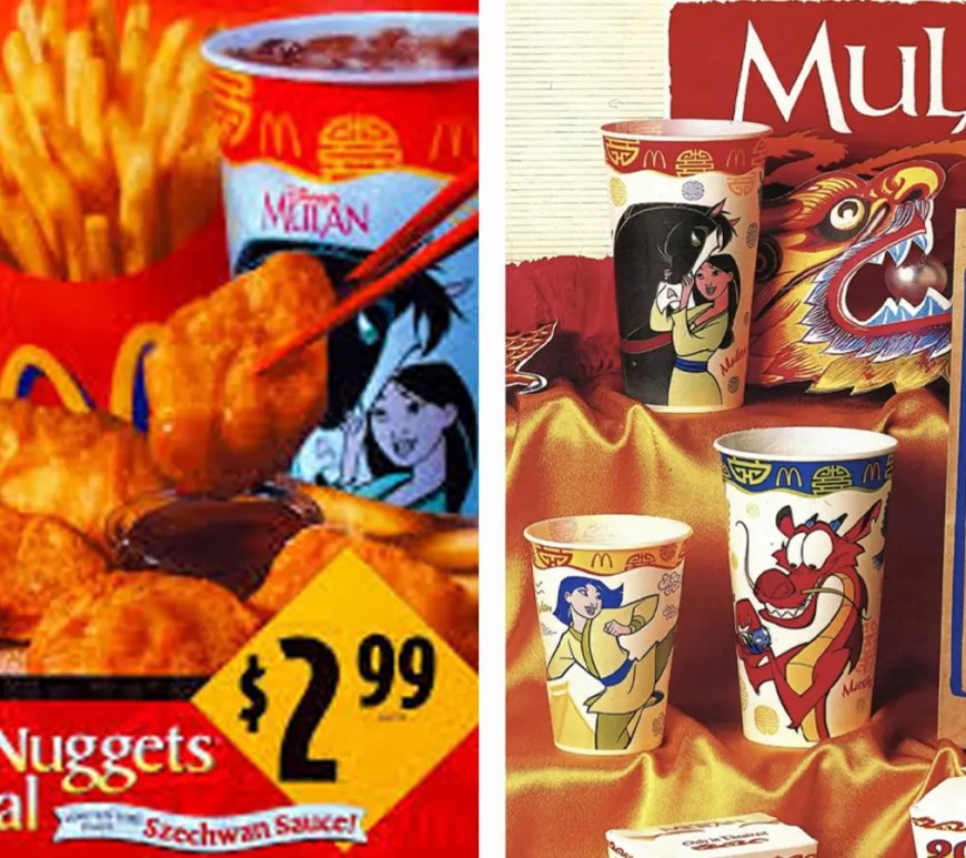 A vintage 1998 McDonald’s Happy Meal display for Disney’s Mulan. The centerpiece is a red Happy Meal box featuring high-action illustrations of Mulan and Mushu. Surrounding the box are several of the eight 'Standard Issue' wind-up toys, including Mulan in her imperial armor, a galloping Khan the horse, and Mushu with his gong. In the foreground is an original, unopened packet of the legendary Szechuan Dipping Sauce, featuring its distinctive purple-and-white foil lid and 1998 Disney copyright branding.