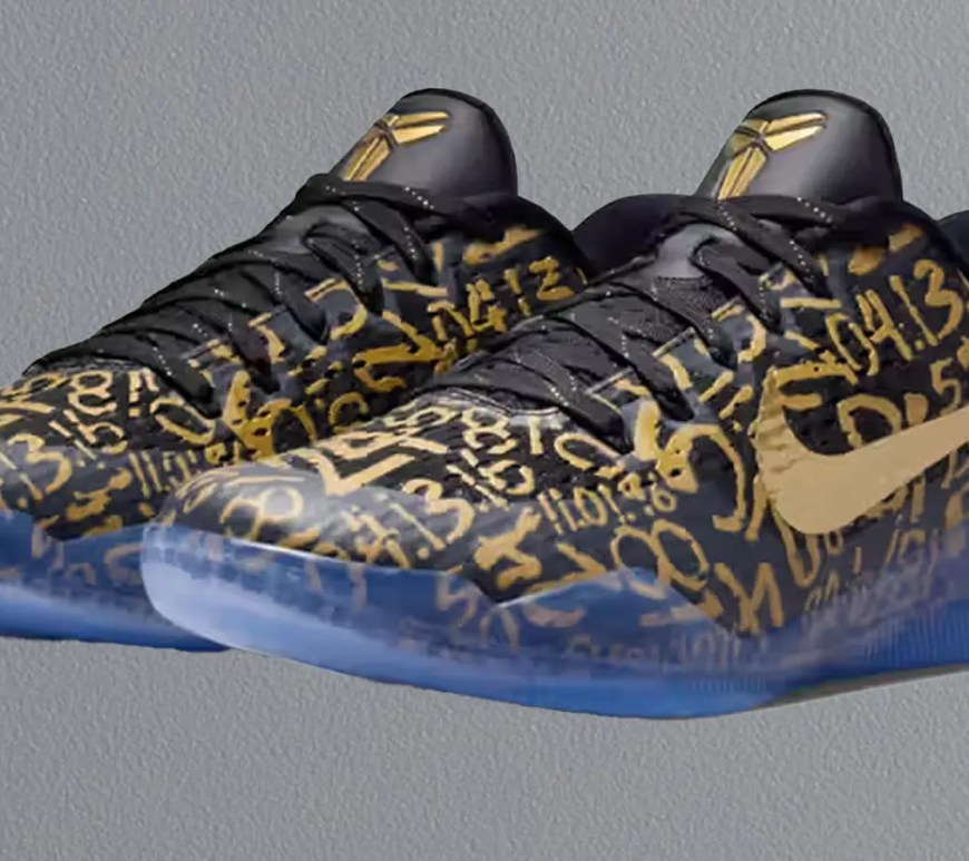 Profile view of the Nike Kobe 11 EM Protro "Mamba Out" featuring a black engineered mesh upper covered in a gold numerical graphic and a metallic gold Swoosh.