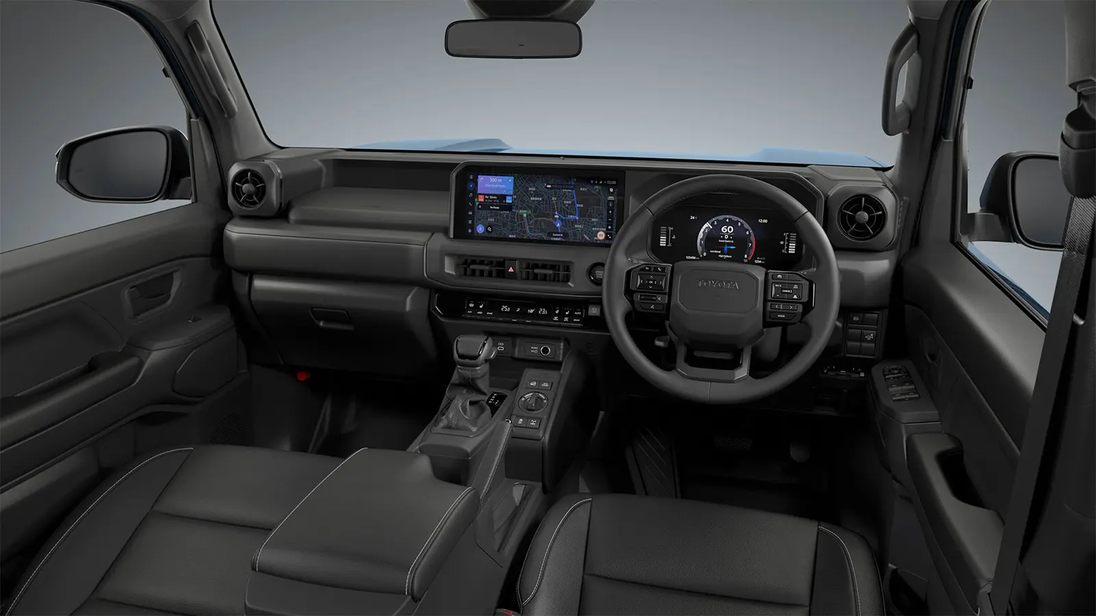 The interior of the 2026 Toyota Land Cruiser FJ in Heritage Blue, showing the retro boxy silhouette and round LED headlights in an off-road mountain setting.