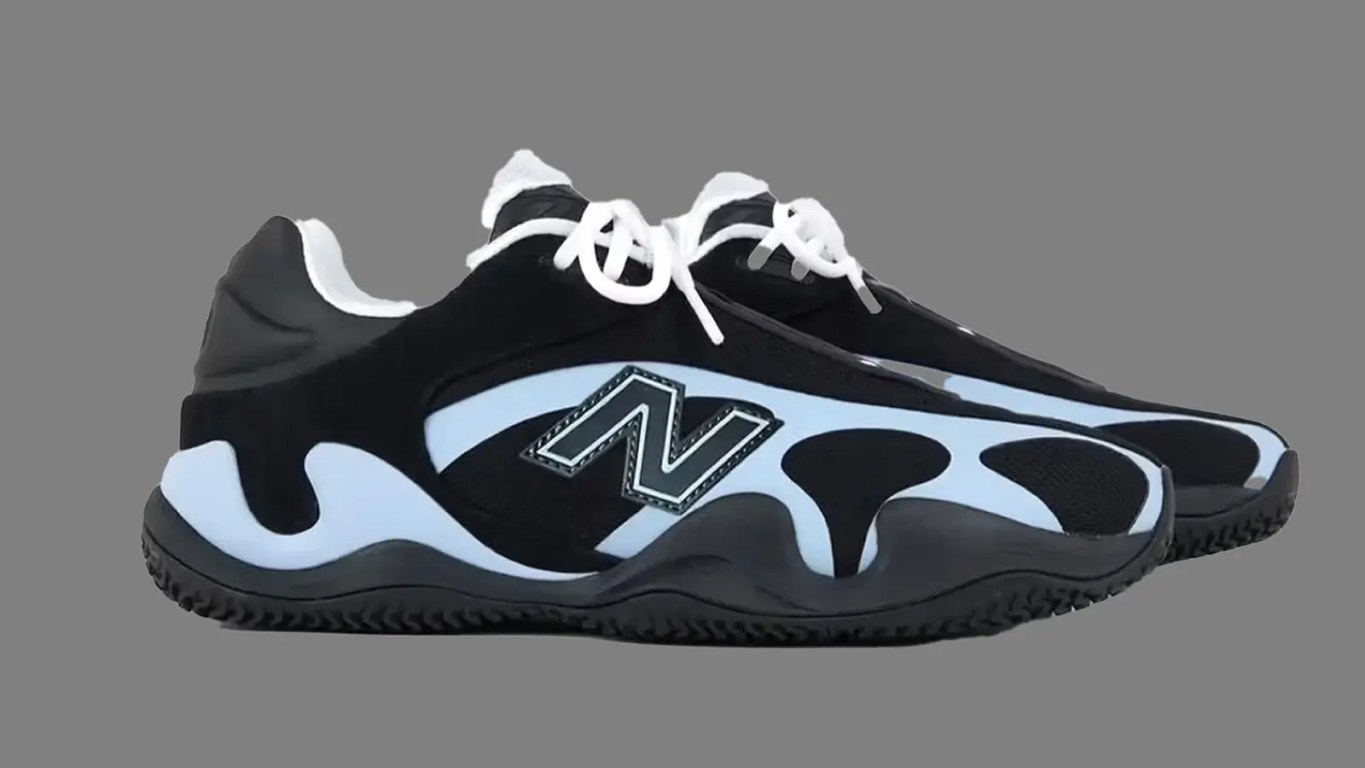 Side view of the New Balance Maxey v1 signature basketball shoe in a black and blue colorway, highlighting the sculpted FuelCell midsole and low-top silhouette against a grey background.