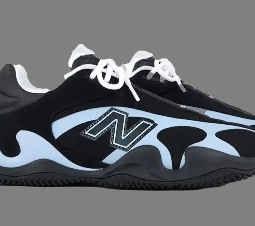 Side view of the New Balance Maxey v1 signature basketball shoe in a black and blue colorway, highlighting the sculpted FuelCell midsole and low-top silhouette against a grey background.
