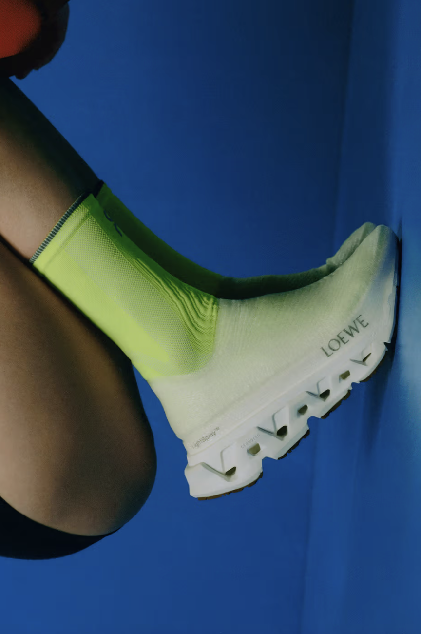 Side profile product shot of the LOEWE x On LightSpray Cloudmonster sneaker in all-white, showcasing its laceless, seamless sprayed-filament upper design and oversized Cloudmonster Hyper midsole unit.