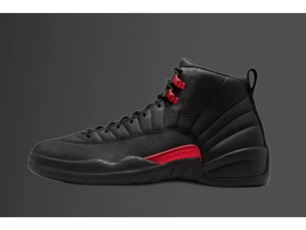 Side profile view of the Air Jordan 12 Bloodline sneaker, highlighting the iconic stitched paneling and the varsity red midfoot branding tab.