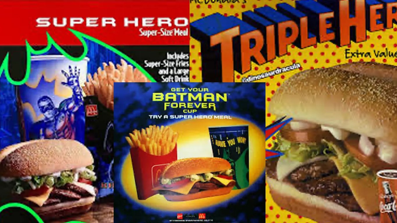 An archival close-up of a 1995 McDonald's promotional store banner for the Super Hero Burger, showcasing the triple-patty layout on an elongated hoagie bun against a neon Batman Forever backdrop.