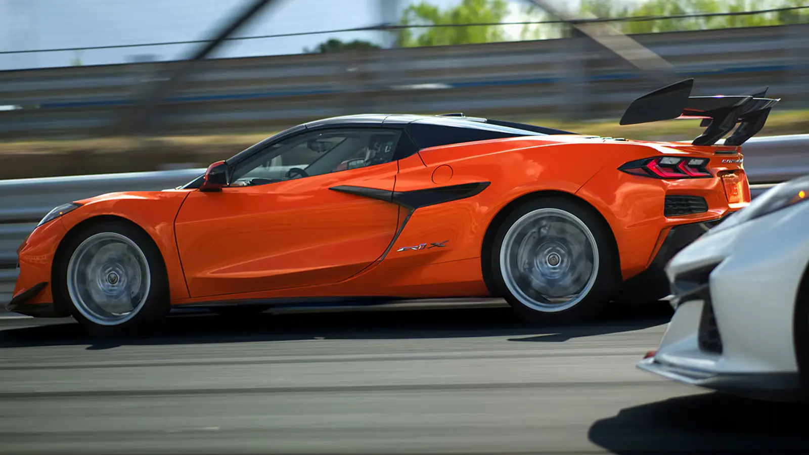 A low-angle exterior profile shot of the 2026 Chevrolet Corvette ZR1X supercar, showcasing its sharp aerodynamic lines, a massive integrated carbon-fiber rear wing, and a sculpted flow-through front hood design built for high-performance thermal cooling.