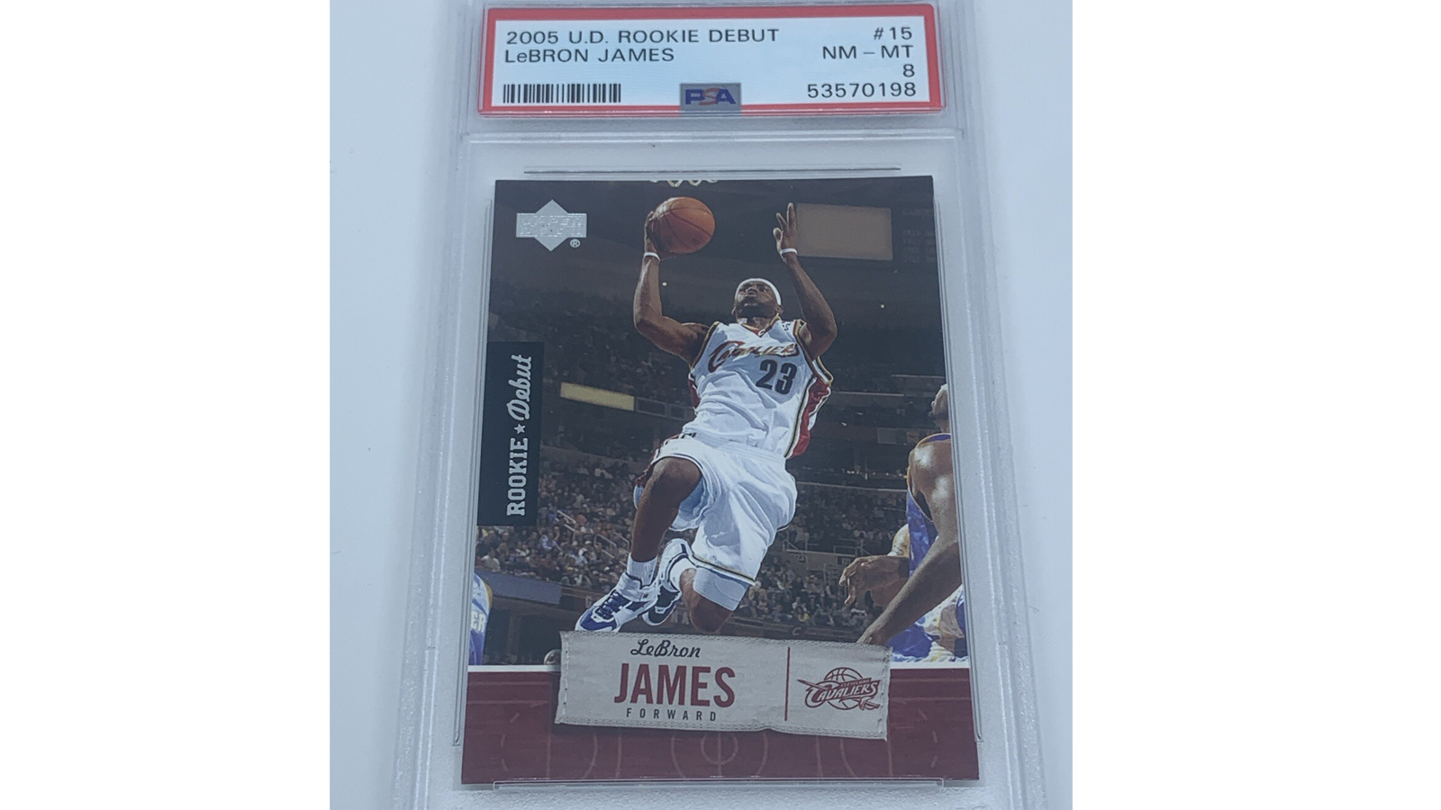 Front profile of the 2005-06 Topps #200 basketball trading card featuring LeBron James of the Cleveland Cavaliers. The card artwork showcases LeBron mid-air executing a powerful one-handed poster dunk in his wine-and-gold uniform, set against a classic white Topps border layout with a dark blue cursive player text block at the bottom.