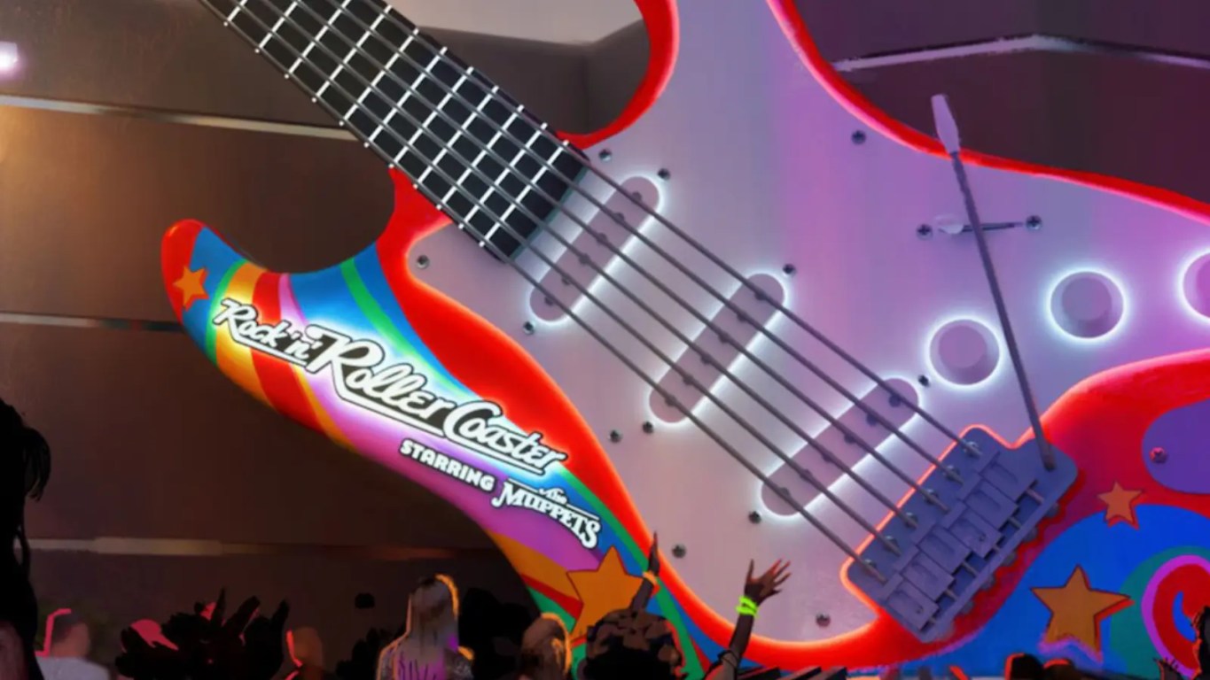 A wide shot of the newly designed Rock 'n' Roller Coaster courtyard at Disney's Hollywood Studios, showing the giant guitar marquee repainted with psychedelic Electric Mayhem colors and updated Muppets branding.