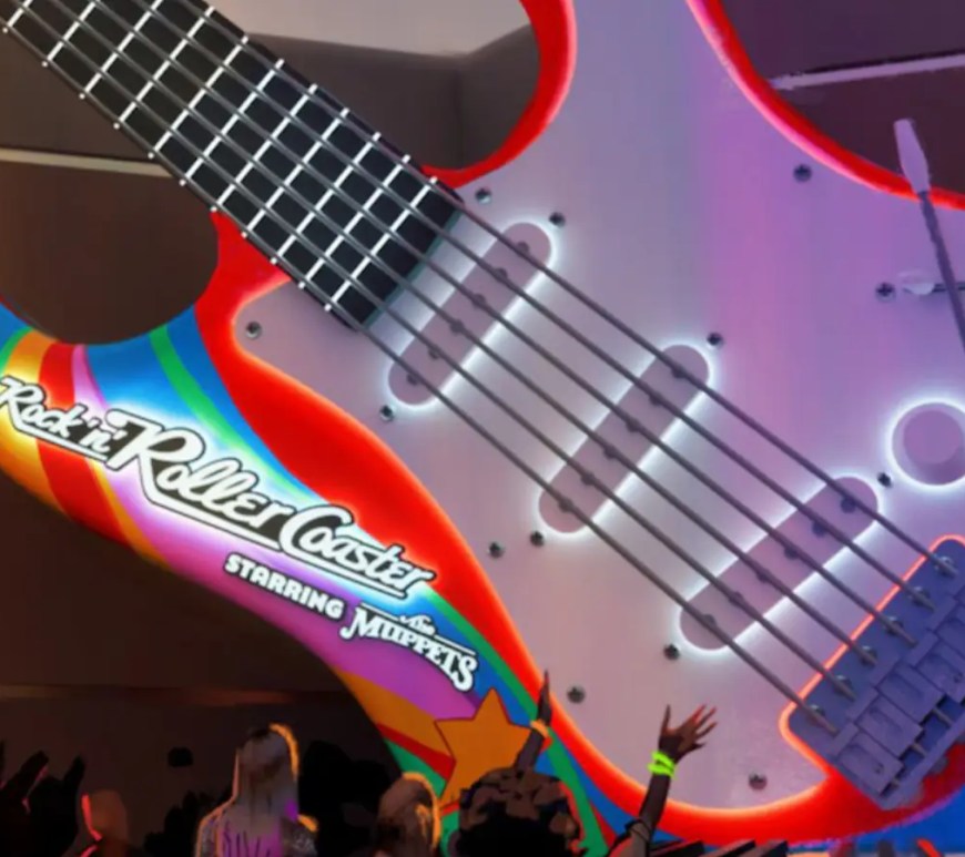 A wide shot of the newly designed Rock 'n' Roller Coaster courtyard at Disney's Hollywood Studios, showing the giant guitar marquee repainted with psychedelic Electric Mayhem colors and updated Muppets branding.