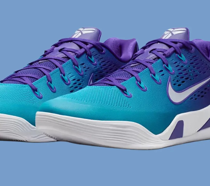 A clean, high-contrast studio front shot of the Nike Kobe 9 Elite Low EM Protro Hornets sneaker, showcasing the purple and teal mesh design details against a blue background.