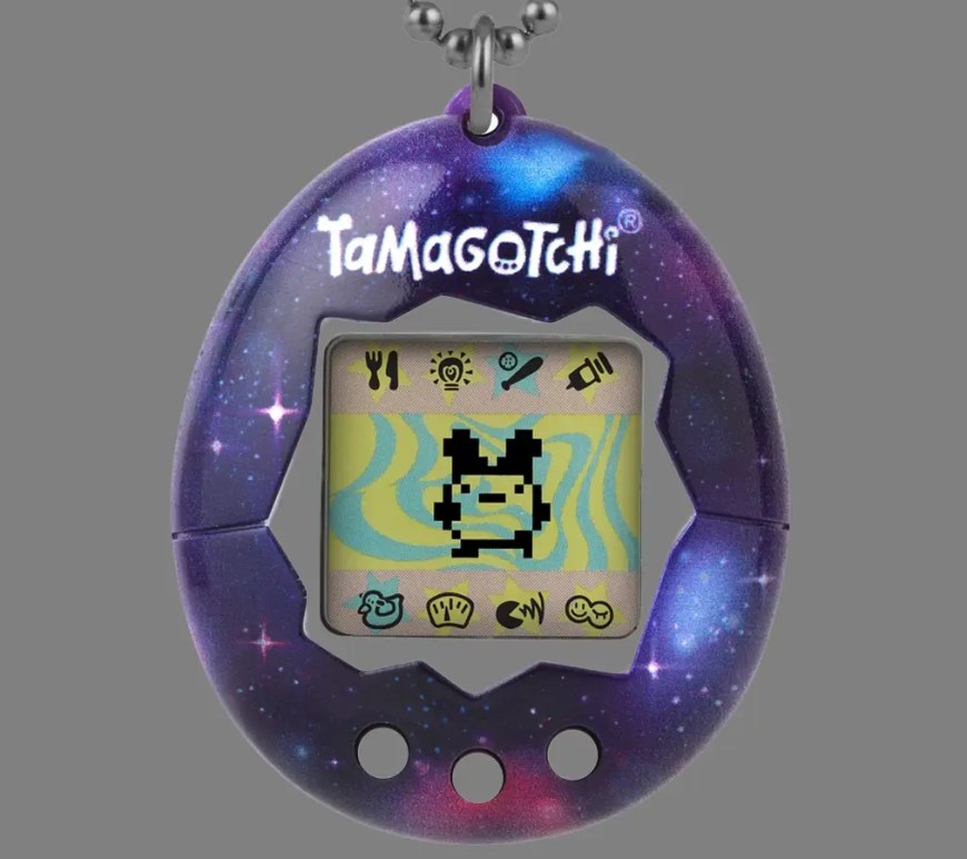 An archival close-up studio shot of a vintage 1997 Gen 1 Bandai Tamagotchi in its iconic translucent blue plastic egg casing, showcasing the 3-button layout and pixelated character on the LCD display.