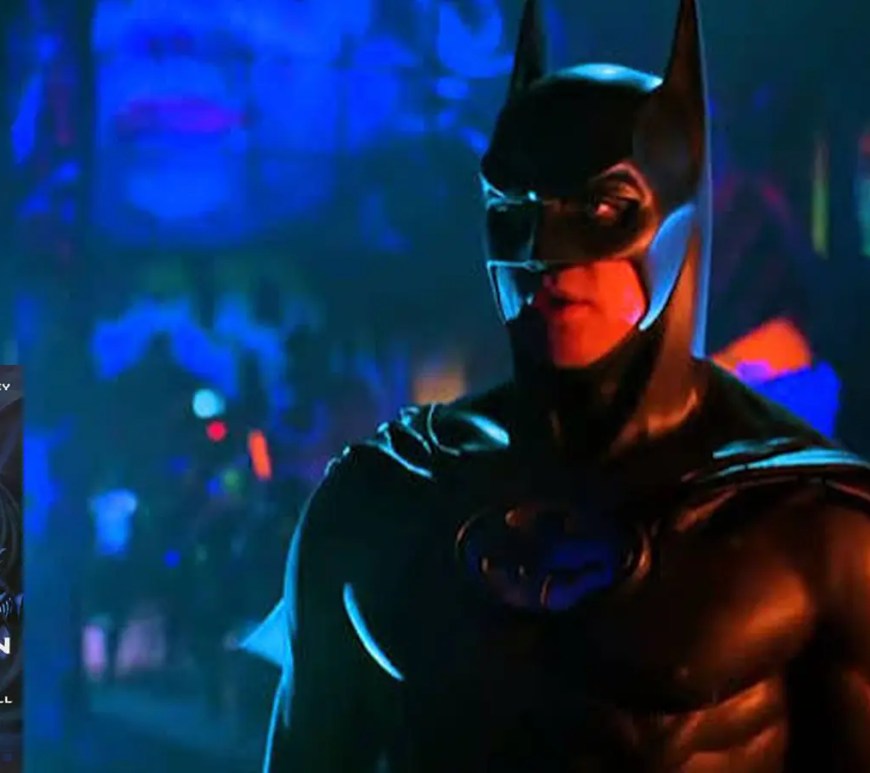 An iconic film still from the 1995 movie Batman Forever, showcasing Val Kilmer as Batman standing against a vibrant neon Gotham backdrop.