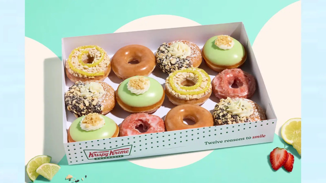 A bright, high-quality product photograph showcasing the new Krispy Kreme Summer Seasonal Collection arranged neatly on a countertop,