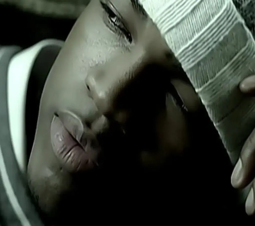 A crisp video production still from 2005 featuring Ne-Yo wearing his signature fedora hat inside a luxury snow-covered cabin in Aspen,
