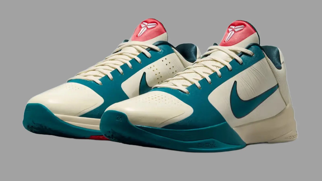 A clean, high-contrast studio front profile shot of the Caitlin Clark x Nike Kobe 5 Protro Scrabble, highlighting the smooth Coconut Milk upper, a vibrant Bright Spruce green Swoosh, and subtle University Red accents on the outsole against a grey background.